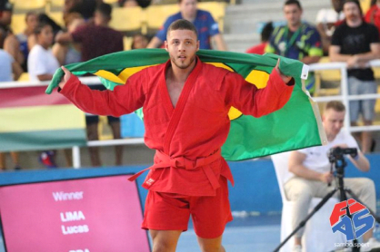 Atleta Lucas Lima, de quimono vermelho, comemora com a bandeira do Brasil nas costas